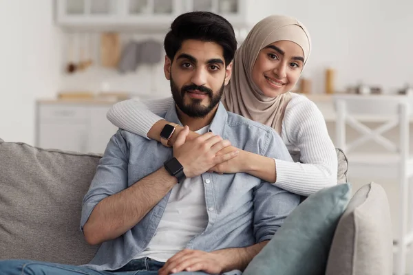 Gut gelauntes Paar lässig zu Hause auf der Couch, schaut in die Kamera, genießt Freizeit, Erholung und Date — Stockfoto