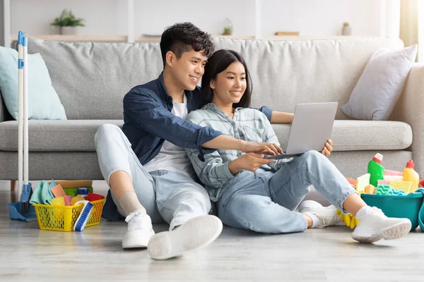 Couple asiatique veulent nettoyer appartement, à la recherche de service en ligne — Photo