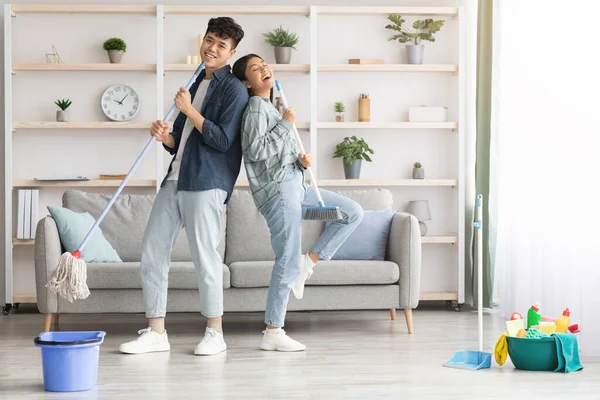 Happy asian couple singing songs while cleaning apartment, copy space — Stock Photo, Image