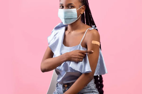 Vaccination from coronavirus. Young black lady pointing at adhesive plaster om her arm after covid immunization — Stock Photo, Image