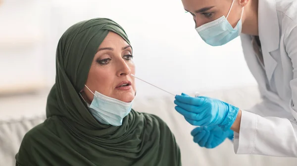 Nurse Testing Muslim Patient For Coronavirus Making PCR Test Indoor — Stock Photo, Image