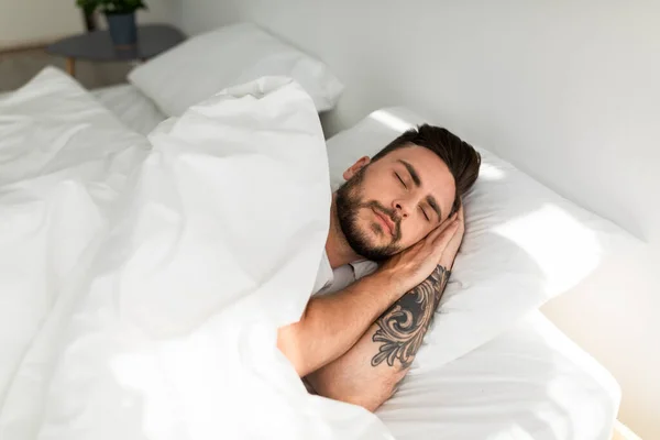 Глубокий мужской сон. Заснул молодой парень мирно спит в своей удобной кровати дома — стоковое фото