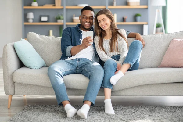 Weekend Pastime. Millennial Interracial Couple Relaxing With Smartphone At Home — 图库照片