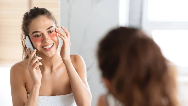 Lady Talking On Cell Applying Pflaster Pflege für die Haut in Innenräumen — Stockfoto