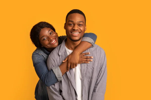 Portrait of young cheerful black couple hugging and smiling at camera — 图库照片