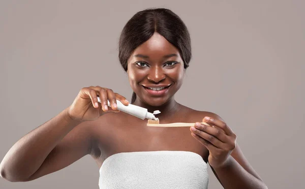 Oral hygien. Vacker svart kvinna Tillämpa tandkräm på Eco Bambu tandborste — Stockfoto
