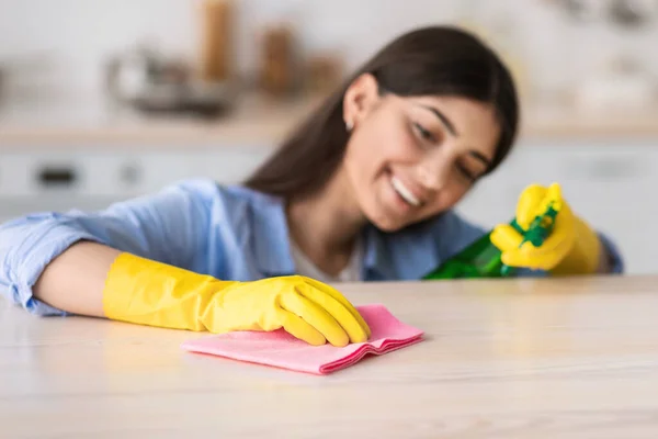 Vrolijke jonge vrouw schoonmaak tafel met doek — Stockfoto