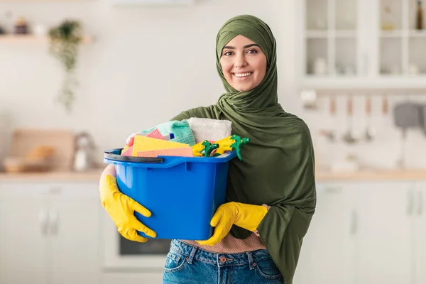 Jovem dona de casa muçulmana segurando balde com ferramentas de suprimentos de limpeza — Fotografia de Stock