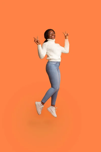 Cheerful Black Woman Jumping In Air And Gesturing Peace With Two Hands — Stock Photo, Image