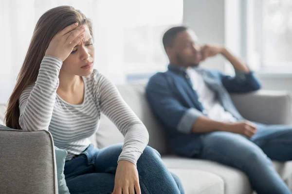 Upset Young Interracial Spouses Sitting On Couch, Ignoring Each Other After Quarrel — 스톡 사진