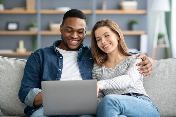 Gelukkig jong interraciaal paar met laptop thuis winkelen Online — Stockfoto