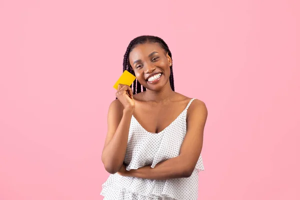 Attractive African American woman showing credit card, advertising bank on pink studio background — 스톡 사진