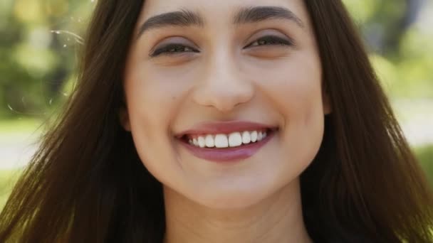 Feliz atraente jovem mulher sorrindo olhando para câmera em pé ao ar livre — Vídeo de Stock