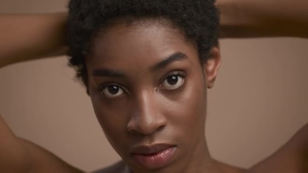 Retrato de sensual joven negra posando sobre fondo beige — Vídeos de Stock