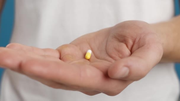 Un remède médical. Gros plan de la capsule médicale dans la main masculine, homme caucasien malade méconnaissable prenant la pilule pour le traitement — Video