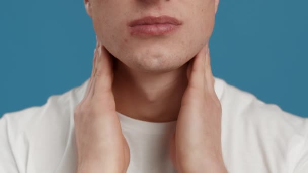 Zánětlivé žlázy. Nerozpoznatelný muž masírující svůj bolestivý krk, trpící zimou nebo chřipkou, modré studio pozadí — Stock video