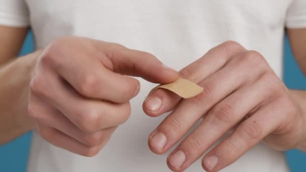 Erste Hilfe nach einem Notfall. Schnappschuss eines kaukasischen Mannes, der medizinisches Klebeband auf schmerzhaften abgeschnittenen Finger legt, Selbstheilung — Stockvideo