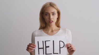 Aile içi şiddeti ve kadın ayrımcılığını durdurun. Kapalı alanda, elinde poster tutan mutsuz kadın portresi.