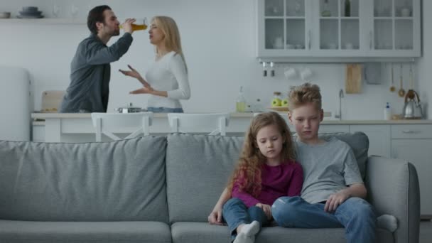 Familienprobleme wegen Alkohol. Betrunkener Ehemann streitet mit unglücklich gestresster Frau, zwei aufgebrachte Kinder sitzen auf Couch — Stockvideo