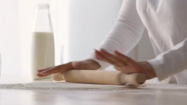 Tanınmayan Afro-Amerikan kadınlarının ahşap broşla hamuru yuvarlarken, mutfakta ev yapımı hamur işi hazırlarken.