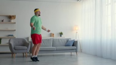 Şişman bir adam ip atlayıp zıplıyor, ama sinirli hissediyor, yere atıyor ve tembellik ediyor.