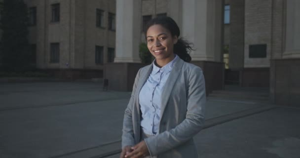 Concepto de carrera exitoso. Zoom en retrato de joven y positiva mujer de negocios afroamericana posando con los brazos cruzados — Vídeos de Stock