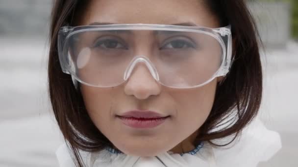 Serious Female Medical Worker Taking Off Protective Glasses Posing Outdoors — Stock video
