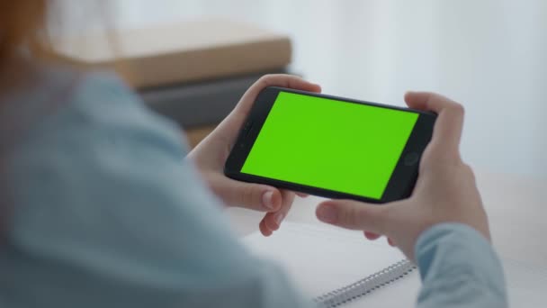 Cursos en línea para niños. Zoom en la toma de teléfono móvil con pantalla de croma verde en las manos de la niña, espacio vacío — Vídeos de Stock