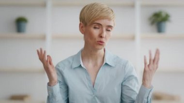 Online danışmanlık. Profesyonel orta yaşlı kadın psikoterapist video blogu kaydediyor, kamerayla konuşuyor.