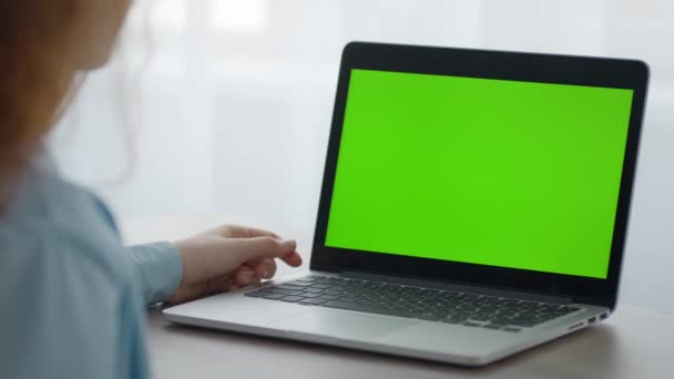 Petite fille méconnaissable regardant des vidéos en ligne sur ordinateur portable avec écran vert chromatique, assis à la maison, espace libre — Video