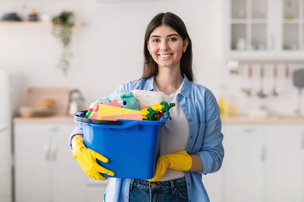 Joven ama de casa sosteniendo cubo con herramientas de limpieza — Foto de Stock