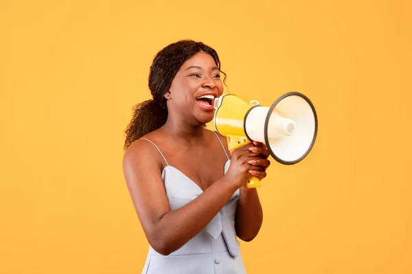 Increíble oferta de compras. Joven mujer negra gritando en megáfono, haciendo anuncio sobre fondo naranja —  Fotos de Stock