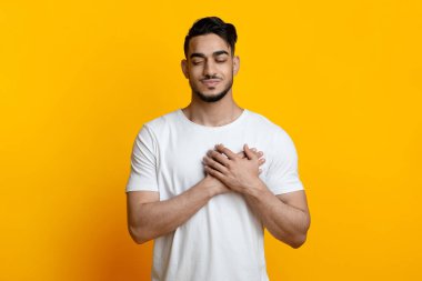 Gözü kapalı, göğsünde el ele tutuşan barışçıl bir Arap.