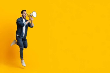 Duygusal Arap adam megafonla zıplıyor, boşluğu kopyalıyor.