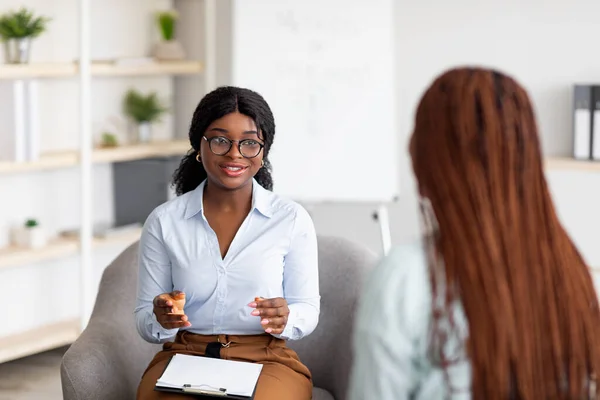 Consulta de psicoterapia. Conselheiro conversando com mulher negra em reunião no escritório, dando conselhos para jovem cliente — Fotografia de Stock