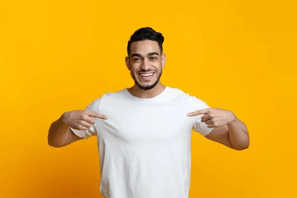 Tipo árabe excitado señalando su camiseta blanca en blanco — Foto de Stock