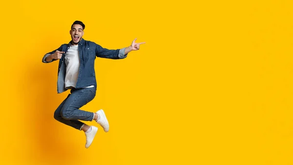 Emocional árabe cara pulando e apontando para o espaço de cópia — Fotografia de Stock