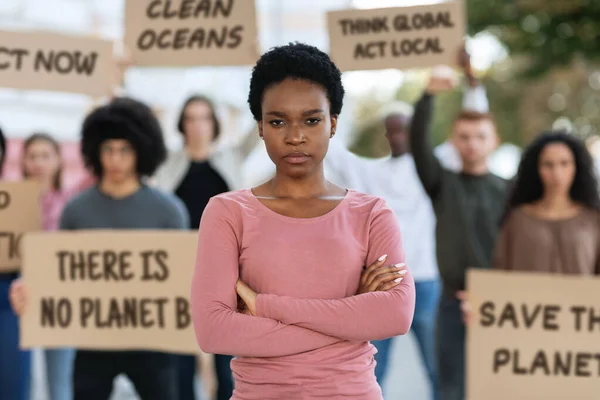 Serious joven negro dama de pie sobre multitud con pancartas — Foto de Stock