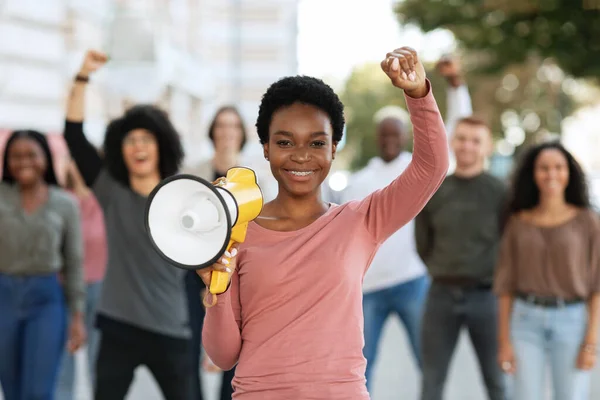 Positive black lady activist with megaphone on the street — стоковое фото