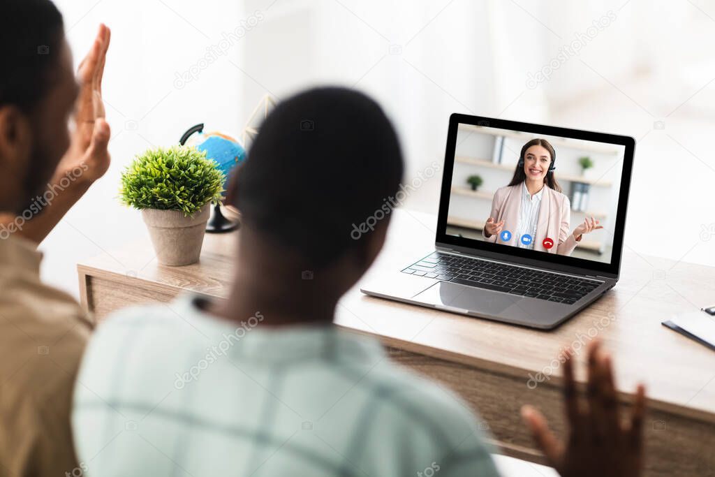 Black Family Couple Having Online Consultation Via Laptop Indoors, Back-View