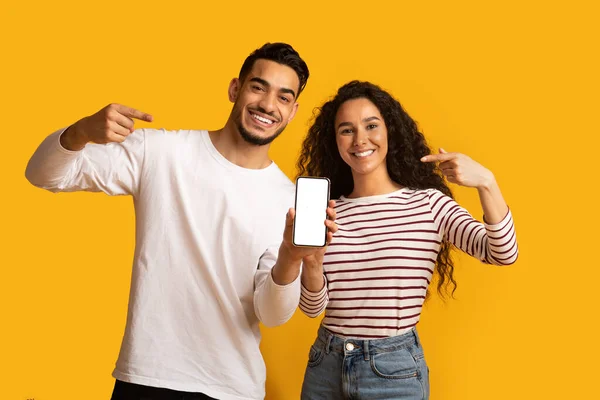 Orta Doğulu Mutlu Çift Boş Akıllı Telefon Moda Ekranı Gösteriyor — Stok fotoğraf