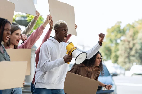 Side view of multiracial people with blank placards chanting slogans — Stock fotografie