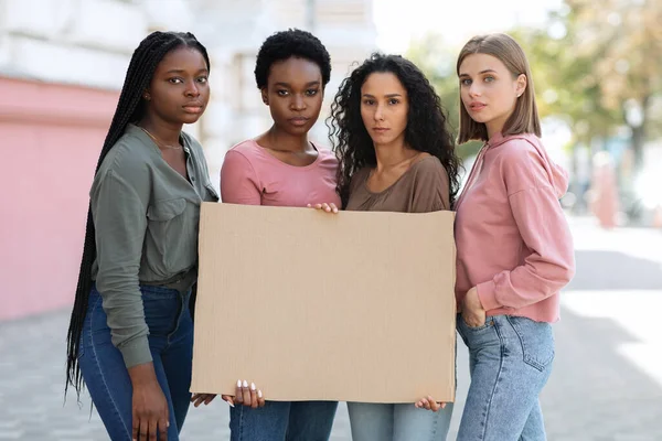 Grupo internacional de quatro jovens mulheres que se manifestam ao ar livre — Fotografia de Stock