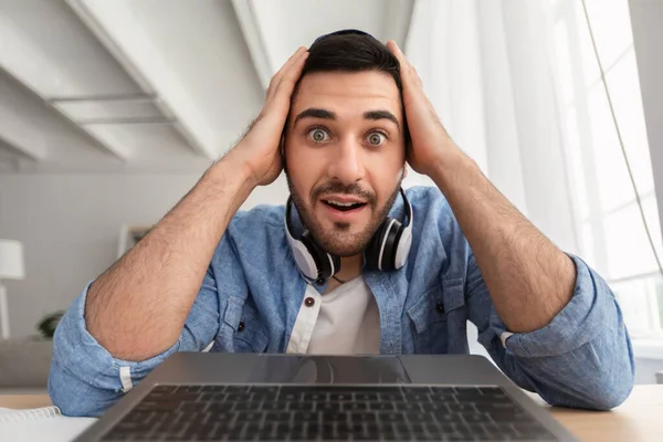 Überraschter Mann telefoniert per Laptop — Stockfoto