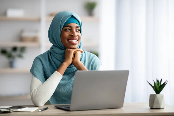 Mosolygó fiatal fekete iszlám nő Hidzsáb ül íróasztal számítógép — Stock Fotó