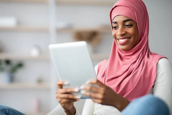 Retrato de jovem mulher negra islâmica com tablet digital relaxante em casa — Fotografia de Stock