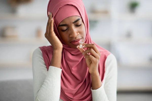 Enfermo negro musulmán mujer en hiyab padeciendo de dolor de cabeza en casa — Foto de Stock