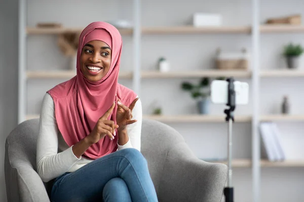 Negro islámica mujer en hijab grabación de vídeo vlog en el teléfono inteligente en casa — Foto de Stock