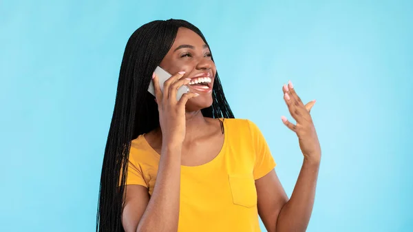 Mulher Africano alegre falando no telefone posando sobre fundo azul — Fotografia de Stock