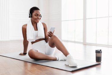 Spor molasında müzik dinleyen siyahi kadın.